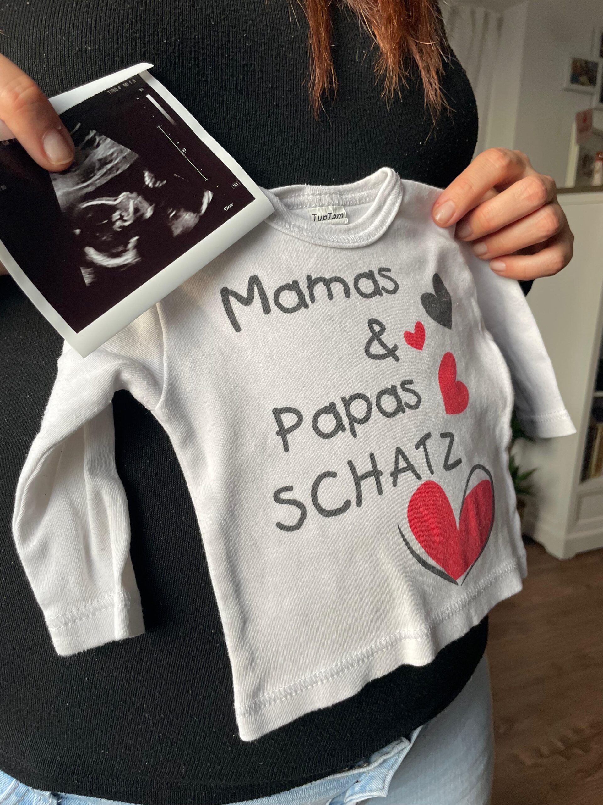 privates Foto - Ariane zeigt ihren Baby-Pullover mit Ultraschallbild